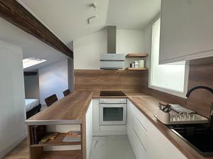 een keuken met witte kasten en een houten aanrechtblad bij Le Graoully 1 in Metz