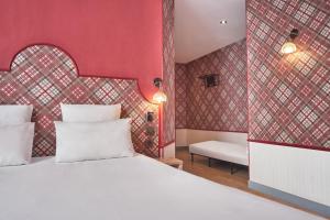 1 dormitorio con cama blanca y paredes rojas en Hotel Boris V. by Happyculture, en Levallois-Perret