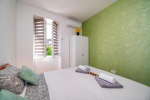 ein Schlafzimmer mit einem großen Bett mit grünen Wänden in der Unterkunft SkyGarden House in Mali Lošinj