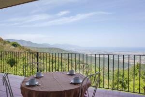 einen Tisch auf einem Balkon mit Aussicht in der Unterkunft Gîtes la fontaine corse vue panoramique in Loreto-di-Casinca