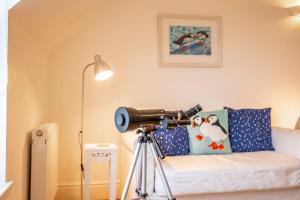 een camera op een statief in een kamer met een bank bij Coastal View - St Monans in Saint Monance