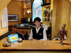 Ein Mann sitzt in einer Bar in einem Restaurant. in der Unterkunft Hotel Calypso in Ventimiglia