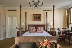 a bedroom with a bed and a desk and a piano at Ettington Park Hotel, Stratford-upon-Avon in Stratford-upon-Avon +44 photos