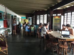 un grupo de personas sentadas en mesas en un restaurante en Pousada Costa Verde Tabatinga, en Ubatuba