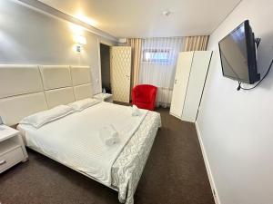 a hotel room with a bed and a flat screen tv at Baiterek Сарайшык 40 in Astana