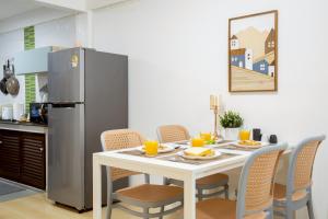 een keuken met een tafel en een koelkast bij Cosy Lodge MRT Phra Ram 9 in Bangkok