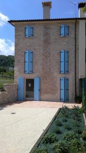 un grande edificio in mattoni con porte blu di Casa Daisy a Castelcucco