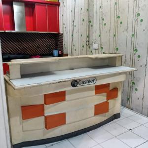 a counter top in a kitchen with red cabinets at Nusantara Center Point By Reccoma in Kayuringin