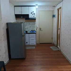 a small kitchen with a refrigerator in a room at Nusantara Center Point By Reccoma in Kayuringin