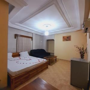 Un dormitorio con una cama grande y un sofá. en Hotel Mboloani, en Lomé