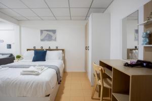 een slaapkamer met een bed en een bureau met een bureau bij Cosy Lodge MRT Phra Ram 9 in Bangkok