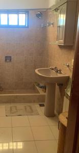 een badkamer met een wastafel en een douche met een bad bij Casa Maru in Villa Carlos Paz