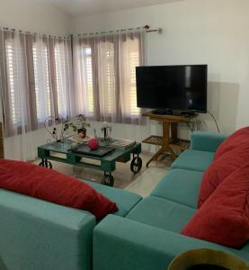 een woonkamer met twee blauwe banken en een tv bij Casa Maru in Villa Carlos Paz