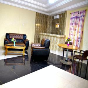 sala de estar con sillas de cuero y mesa en Hotel Mboloani, en Lomé