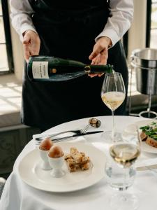 a person pouring a glass of wine over a table at Ettington Park Hotel, Stratford-upon-Avon in Stratford-upon-Avon
