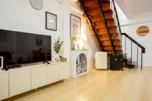 een woonkamer met een grote flatscreen-tv bij Cosy Lodge MRT Phra Ram 9 in Bangkok