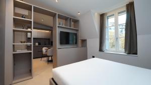 a bedroom with a bed and a window and a television at Be Mate Citylife in Milan