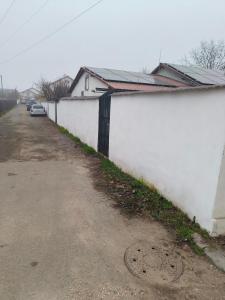 a white fence next to a road next to a building at Casa Razu G2 in Craiova +17 photos
