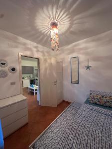 een slaapkamer met een bed en een plafond met een kroonluchter bij Delphina House in Lido delle Nazioni +30 foto's