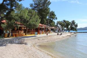 a beach with a group of people sitting on the shore at Mobil home Katka in Biograd na Moru