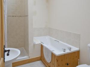 a bathroom with a tub and a sink and a toilet at Jenny Wren in Flamborough