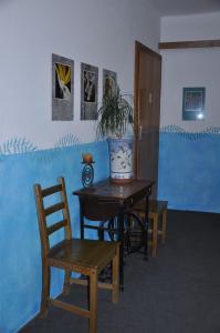 チェスキー・クルムロフにあるPension U Galerieのテーブルと椅子、鉢植えの植物が備わる部屋