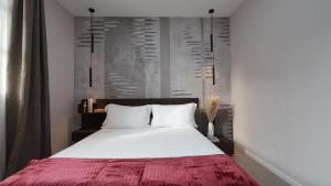 a bedroom with a white bed with a red blanket at Be Mate Citylife in Milan