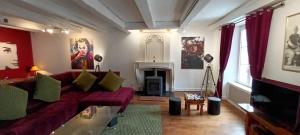 Una sala de estar con un sofá rojo y una chimenea. en Place of the Goddess, en Damvillers