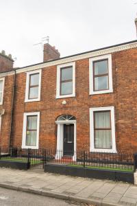 een bakstenen gebouw met een zwart hek ervoor bij The Woodrouffee retreat in Carlisle