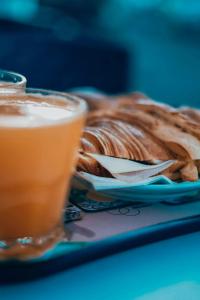 une assiette de nourriture avec une boisson à côté d'une tarte dans l'établissement Casa das Orquídeas Meco, à Sesimbra