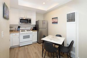 Una cocina con refrigerador y una mesa con sillas. en Sunny Sands Retreat, en Oceano