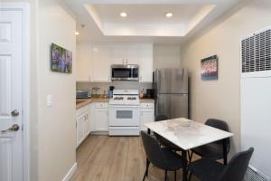 Una cocina con gabinetes blancos y una mesa con sillas. en Sunny Sands Retreat, en Oceano