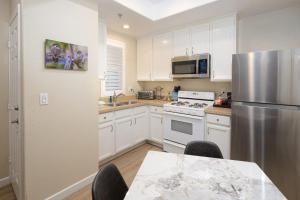 Una cocina con gabinetes blancos y un refrigerador de acero inoxidable. en Sunny Sands Retreat, en Oceano 9 fotos más