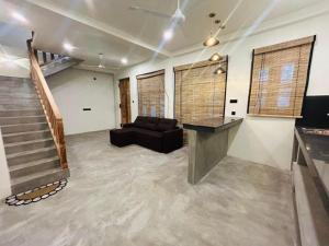 a large living room with a couch and a staircase at Tiny house in Ahangama
