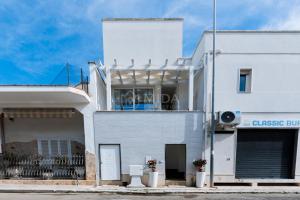 a white building with a balcony on top of it at Artemar in Porto Cesareo