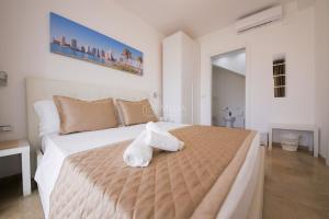 a bedroom with a large bed with towels on it at Artemar in Porto Cesareo