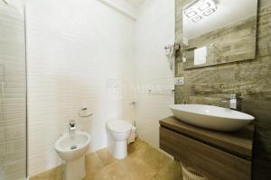 a white bathroom with a sink and a toilet at Artemar in Porto Cesareo +6 photos
