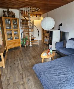 een woonkamer met een bed en een wenteltrap bij Ferienhaus Rhönblick in Bischofsheim an der Rhön