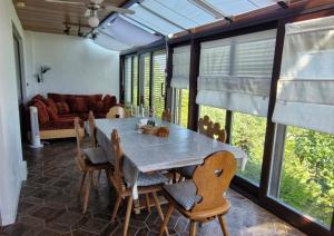 a dining room with a table and chairs and a couch at Ferienhaus Rhönblick in Bischofsheim an der Rhön