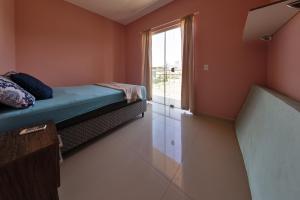 a small room with a bed and a window at Residencial Beija-Flor in Palhoça