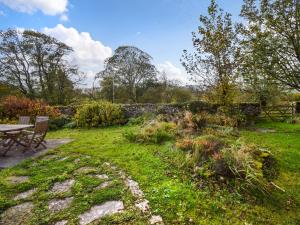 een tuin met een picknicktafel en een stenen muur bij Low Lane Cottage in Crosby Garrett