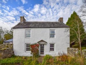 een wit huis met bloemen ervoor bij Low Lane Cottage in Crosby Garrett