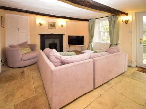 een woonkamer met twee banken en een open haard bij Low Lane Cottage in Crosby Garrett