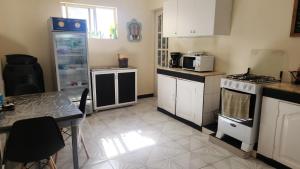 uma cozinha com electrodomésticos brancos e uma mesa em Meeting Point Hostels-Praia Beachwalk-NO CASH ACCEPTED-Also in Fogo & Tarrafal em Praia