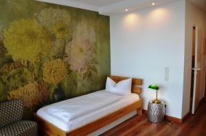 a bedroom with a painting of flowers on the wall at Wohnfakturei in Augsburg
