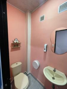 a pink bathroom with a toilet and a sink at La Casa de Adry in Cali