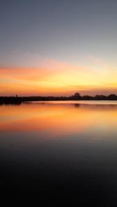 a large body of water with a sunset in the background at Aqua Vista Studio Appartment in Tangalle