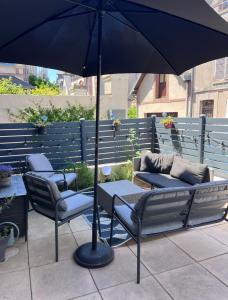 a table and chairs under an umbrella on a patio at Belle Maison centre Villerville - 8 personnes - Terrasse in Villerville +26 photos