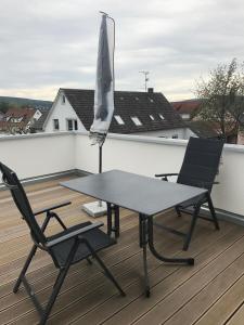 a table and two chairs on a deck with an umbrella at Seeterrasse in Allensbach