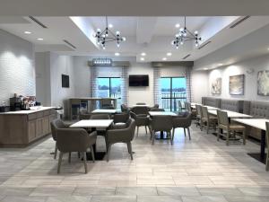 um restaurante com mesas, cadeiras e um bar em Merica Inn & Suites em Wills Point